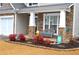 Inviting front porch with stone accents, a cozy bench, and well-maintained landscaping with colorful plants at 2481 Southhaven Ln, Buford, GA 30519