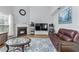 Living room featuring a fireplace, hardwood floors, leather couches, and tall windows for natural light at 2481 Southhaven Ln, Buford, GA 30519