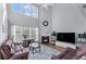 Spacious living room with high ceilings, a fireplace, and a large TV for comfortable entertaining at 2481 Southhaven Ln, Buford, GA 30519