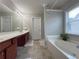 Main bathroom featuring a soaking tub, vanity and a window at 2481 Southhaven Ln, Buford, GA 30519