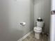 Modest half bathroom with neutral tones, a toilet, and a small sink at 2481 Southhaven Ln, Buford, GA 30519