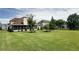 Beautiful backyard featuring a well-manicured lawn, mature trees, and a screened porch at 5345 Glenhaven Dr, Cumming, GA 30041