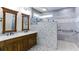 Modern bathroom boasting a double vanity with wood cabinets, decorative mirrors, and a glass-enclosed shower at 5345 Glenhaven Dr, Cumming, GA 30041