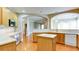 Bright kitchen featuring wood cabinets, white countertops, and wood floors, with archways leading to other living spaces at 5345 Glenhaven Dr, Cumming, GA 30041