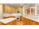 Well-lit kitchen with wooden cabinetry, white countertops, stainless steel appliances, and hardwood flooring at 5345 Glenhaven Dr, Cumming, GA 30041