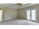 Spacious main bedroom featuring tray ceilings and french doors leading to a balcony or patio at 5345 Glenhaven Dr, Cumming, GA 30041