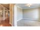 Neutral room with plush carpeting, white trim, and adjacent hallway with decorative pillars and wood flooring at 5345 Glenhaven Dr, Cumming, GA 30041