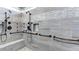 Luxurious walk-in shower with gray tiling, multiple shower heads, and a built-in bench at 5345 Glenhaven Dr, Cumming, GA 30041