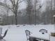 Snowy backyard featuring mature trees, outdoor seating and a swing set at 969 Golden Meadows Ln, Loganville, GA 30052