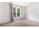 Bright bedroom featuring neutral carpet, a chandelier, and a window with gray and pink curtains at 1469 Crescent Walk, Decatur, GA 30033
