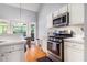 Bright kitchen features stainless appliances, white cabinets, and hardwood floors by the breakfast nook at 1469 Crescent Walk, Decatur, GA 30033