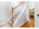 Carpeted staircase with white banisters and wooden handrail, leading to the upper level and a view of the living area at 1469 Crescent Walk, Decatur, GA 30033
