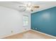 Bedroom with wood flooring, a ceiling fan, a window, and one wall painted blue at 364 Stafford Sw St, Marietta, GA 30064