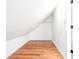 A finished attic space with white walls and wood-look flooring with a simple closet rod at 5491 Hiram Rd, Powder Springs, GA 30127