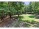 Backyard features a secure wood fence and gate, offering privacy, lush vegetation and manicured lawn at 5491 Hiram Rd, Powder Springs, GA 30127