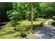 Idyllic backyard featuring a green lawn, mature trees, and a charming fence-lined border at 5491 Hiram Rd, Powder Springs, GA 30127