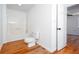 Bright bathroom features a shower-tub combo with a white toilet and modern wood-look flooring at 5491 Hiram Rd, Powder Springs, GA 30127