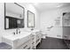 Modern bathroom with double farmhouse sink, black tiled shower, and sleek black fixtures at 5491 Hiram Rd, Powder Springs, GA 30127