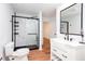 Modern bathroom featuring a glass-enclosed shower, white vanity, and sleek fixtures with wood-look flooring at 5491 Hiram Rd, Powder Springs, GA 30127