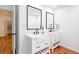 Bathroom features double sinks, large mirrors, and modern fixtures with wood-look flooring at 5491 Hiram Rd, Powder Springs, GA 30127