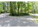 Circular gravel driveway leading to the property, surrounded by towering trees and lush greenery at 5491 Hiram Rd, Powder Springs, GA 30127