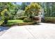 Charming single Gathering home with a front porch, lush greenery and a concrete driveway in a wooded area at 5491 Hiram Rd, Powder Springs, GA 30127