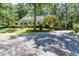 Charming single Gathering home featuring a classic front porch, lush greenery and ample gravel driveway at 5491 Hiram Rd, Powder Springs, GA 30127