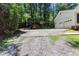 Three-car garage with gravel driveway, play equipment, and basketball hoop, set amid lush greenery at 5491 Hiram Rd, Powder Springs, GA 30127