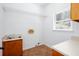 Laundry room with a utility sink, tile flooring, storage cabinets, and a window at 5491 Hiram Rd, Powder Springs, GA 30127
