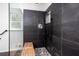 Walk-in shower features sleek black slate tile, a bench, and modern fixtures at 5491 Hiram Rd, Powder Springs, GA 30127