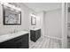 Bathroom featuring dual vanities and a walk in shower with marble tiling at 990 Trestle Dr, Austell, GA 30106