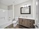 Updated bathroom with modern vanity, framed mirror, and shower-tub combo at 990 Trestle Dr, Austell, GA 30106