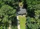 Aerial view of a home surrounded by lush trees and a green lawn at 3267 Sunderland Dr, Snellville, GA 30039