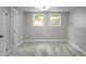 Bright basement with gray carpet and neutral paint, featuring natural light from two windows at 3267 Sunderland Dr, Snellville, GA 30039
