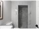 Bathroom featuring a toilet and a gray tiled walk-in shower with pebble floor at 3267 Sunderland Dr, Snellville, GA 30039