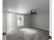 This bedroom features neutral walls, gray carpet, a ceiling fan, and a window with a wooded view at 3267 Sunderland Dr, Snellville, GA 30039