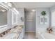 Elegant bathroom featuring double vanity with granite countertop, soaking tub, decorative mirrors, and tiled floor at 3370 Battlement Cir, Loganville, GA 30052