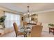 Elegant dining room with a glass-top table, chandelier, and large windows at 3370 Battlement Cir, Loganville, GA 30052