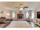 Spacious Gathering room with a fireplace, ceiling fan, and large windows offering ample natural light at 3370 Battlement Cir, Loganville, GA 30052