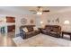 Inviting living room featuring two leather sofas, stylish decor, ceiling fan, and a neutral area rug over hardwood flooring at 3370 Battlement Cir, Loganville, GA 30052