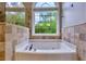 Bathtub with tile surround and a window view at 4167 Alayna Lee Cir, Mcdonough, GA 30252