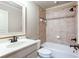 Bathroom featuring a shower-tub combo with beige tiling and bronze fixtures at 240 Chandler Walk, Loganville, GA 30052