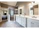 Bright bathroom featuring double vanity, tiled floors, and walk-in shower with decorative tile and glass door at 240 Chandler Walk, Loganville, GA 30052