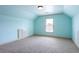 A minimalist bedroom with sky blue walls, neutral carpet, and an alcove with built in cabinet at 240 Chandler Walk, Loganville, GA 30052