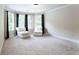 Bedroom with a bay window and two chairs, featuring neutral decor and carpet at 240 Chandler Walk, Loganville, GA 30052