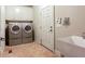 Laundry room featuring washer, dryer, cabinets, sink and entry door at 240 Chandler Walk, Loganville, GA 30052