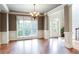 Spacious living room with a large window, chandelier, and beautiful hardwood floors at 240 Chandler Walk, Loganville, GA 30052