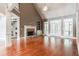 Living room with fireplace, built-ins, hardwood floors, and vaulted ceiling at 240 Chandler Walk, Loganville, GA 30052
