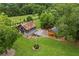 Aerial view of a charming barn with a rustic roof and outbuildings on a sprawling green lawn at 4239 Lower Jersey Rd, Covington, GA 30014