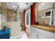 Bright bathroom featuring granite counters, glass shower, blue vanity and warm neutral wall colors at 4239 Lower Jersey Rd, Covington, GA 30014